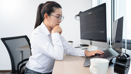 Young Asian woman Programmer Typing code working with computer at table, coding cyberspace and Web Development Concept.の写真素材