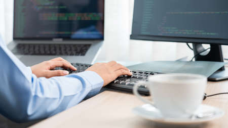 Asian woman Programming working with computer and typing data code to developing program at table In...