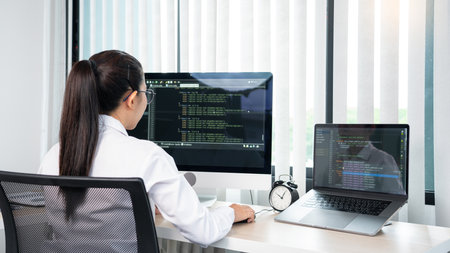 Asian Woman programmer typing source codes Programming On Computer in office, freelance web...