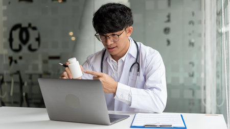Medical, a male doctor attending online meeting pointing at the pill bottle to explain the pillâs properties.の写真素材