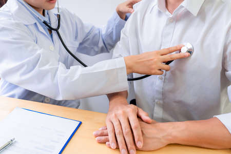 Medical concept a female doctor examining the patient by using stethoscope on the patientâs breast.の写真素材