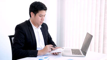 Business concept a male accountant using a calculator counting companyâ€™s profits and losses,...