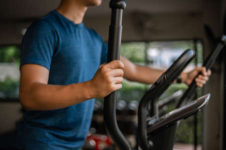 Training gym concept a male teenager doing cardio workout on cycling machine in the gym as his...