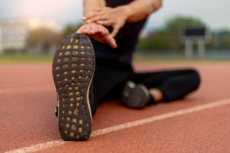 Sports and recreation concept a male youth doing warm-up by stretching each part of his body as preparation before exercise.の写真素材