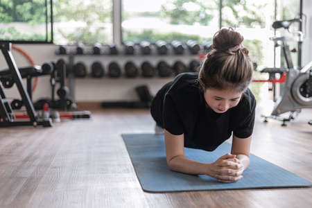 Training gym concept a female teenager doing planking and holding the position for a while as her abdominal and core exercise.の写真素材
