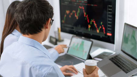 Financial concept two investor partners analyzing the growths of the stock from the chart before...