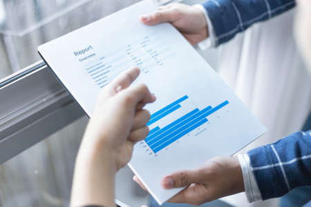 Business partners concept a young businessman creating profit summary of the recent month showing in document forms.の写真素材