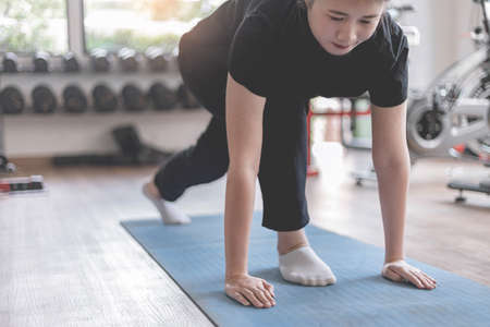 Training gym concept a female teenager doing planking and holding the position for a while as her...