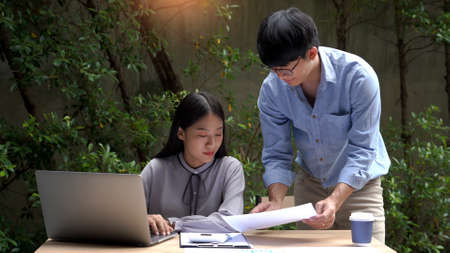 Working outdoor concept a female officer talking with her supervisor to solve the problems of the project together in the officeâs green working spaceの写真素材