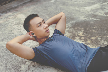 Sports and recreation concept a male adolescent doing warm-up movements as raising his body...