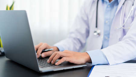 Medical concept a male doctor wearing a mask searching information about Coronavirus (COVID-19) for...