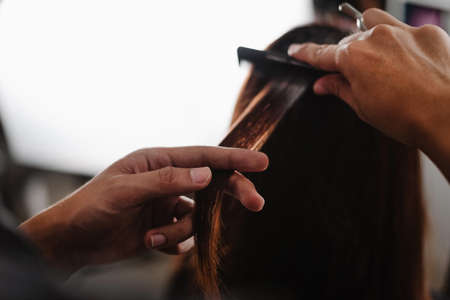 Hair salon concept a male hairstylist working with scissors cutting and styling a female customerâs hair.の写真素材
