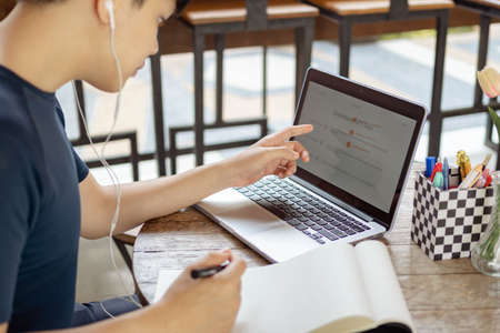 Online studying concept the stock controller pointing his finger at the silver computer laptop to...