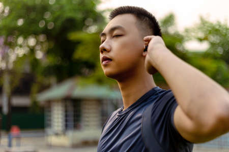 Sports and recreation concept a male adolescent doing warm-up movements as raising his body...