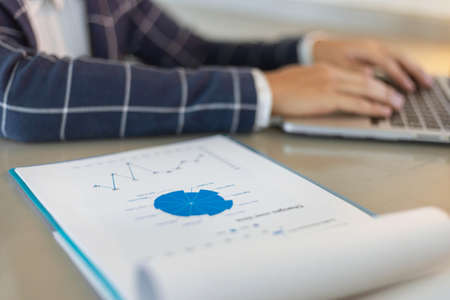Business partners concept a young businessman using a laptop revising annual sales summary.の写真素材