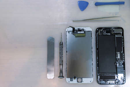 Phone repair concept the components of the smartphone separated into parts nearby the stainless...