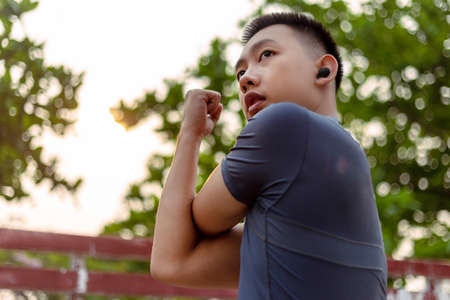 Sports and recreation concept a male adolescent doing warm-up movements as raising his body temperature and increasing blood flow to his muscles.の写真素材