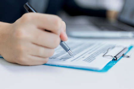 Business partners concept a young male entrepreneur signing a signature on the contract with a big...