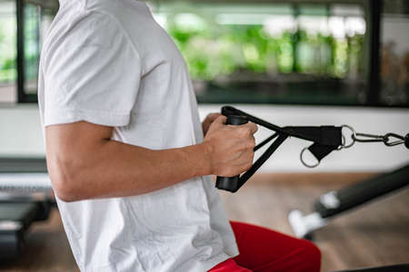 Training gym concept a muscled male teenager using a gym equipment repeating pushing forward for...