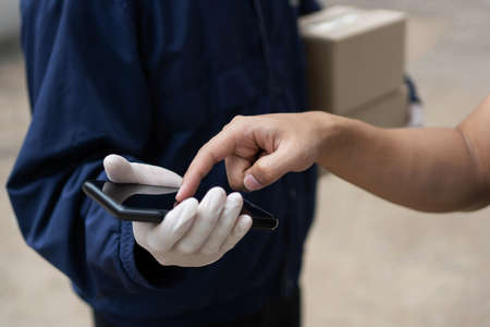 Parcel delivery concept the client pointing to confirm the ordered items at black smartphone on the...