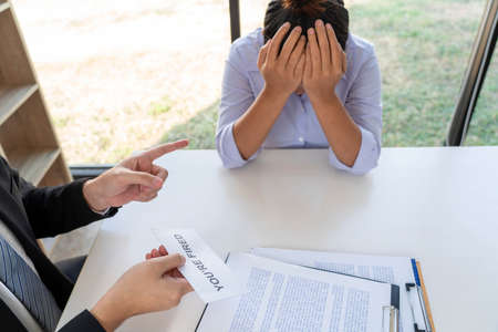 Dismissal concept a female officer fired by the boss looking very sad after she committed a big mistake.の写真素材