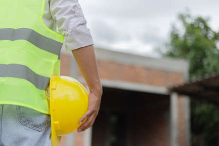 engineer concept The male constructing staff that wears a white top covered with bright lime vest, a...