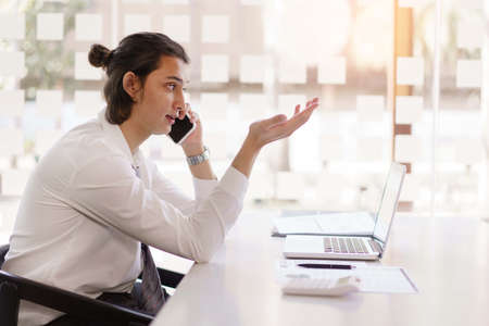 Business concept, Businessman is using phone to talking about planning project with team colleague.