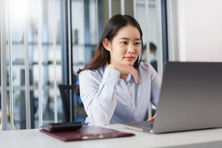 Business concept, Businesswoman thoughtful about new project while reading marketing data on laptop.の写真素材