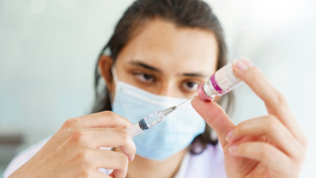 Vaccination concept, Male doctor in medical mask preparing vaccine against covid-19 for people.の写真素材