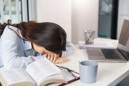Business concept, Businesswoman sleeping during break time from hard working on the desk in office.の写真素材