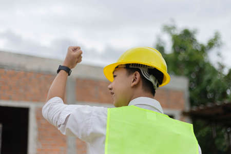 engineer concept The constructing guy looking at the construction site and raising his hands for...