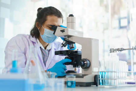 Laboratory research concept, Scientist working in lab with microscope to research drug and vaccine.