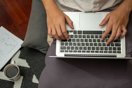 Remote work concept, Male freelancer use laptop to typing business data and working in living room.