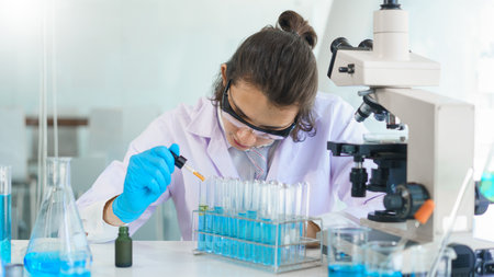 Laboratory research concept, Scientist working in lab to drop of solution into tube for research.