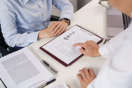 Business concept, Business colleague pointing on document to explain financial data to partner.