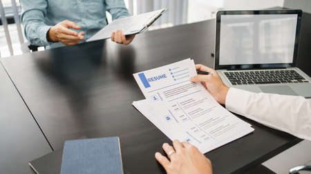 Recruitment concept, Male employer read resume while applicants explaining CVs and work experiences.の写真素材