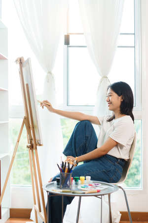 The art concept, Asian female artist using paint brush to painting for create artwork on canvas.の写真素材