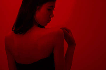 Fashion and beauty concept, Fashion woman in black dress to pose in neon light background.