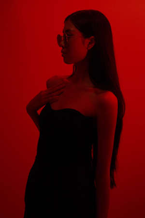 Fashion and beauty concept, Fashion woman is wearing sunglasses to posing on neon light background.の写真素材
