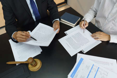 Lawyer and justice concept, Businessman signs contract after senior lawyer explains details.