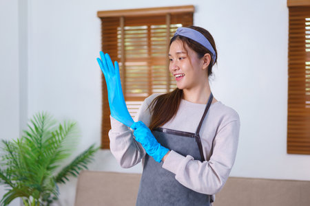 Housework concept, Housemaid is wearing gloves and apron to prepare cleaning the house.の写真素材