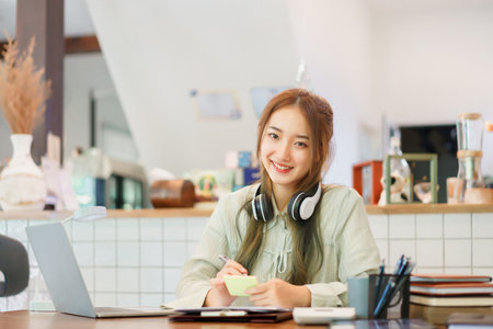 Business concept, Woman entrepreneur writing idea in post it notes while working in coworking space.