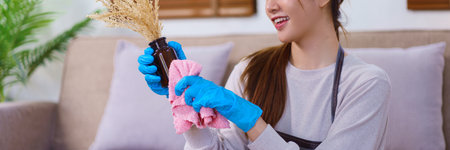 Housekeeping concept, Housemaid is use a cloth to cleaning the flower vase while cleaning the house.