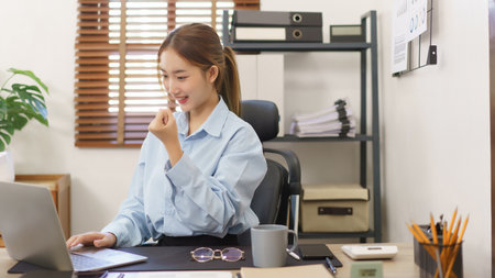 Business concept, Businesswomen raise arm in celebrate after receive good news at workplace.の写真素材