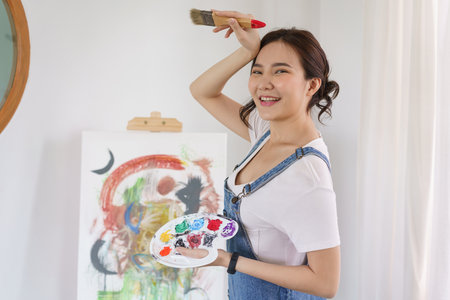 Creative of art concept, Young asian woman holding paint brush and color palette to drawing the art.の写真素材