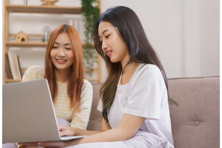 Activity at home concept, LGBT lesbian couple read and typing data on laptop while working together.の写真素材