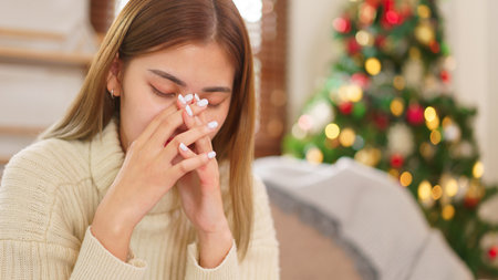 Winter season concept, Women stressed and exhausted while resting on couch near christmas tree.