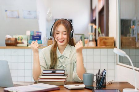 Coworking space office concept, Woman entrepreneur raise arms to celebrate after completing meeting.の素材