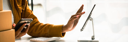 African american woman use smartphone to checking shopping online order and working in home office.の写真素材