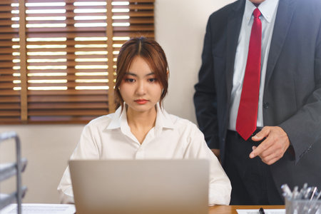 Financial business concept, Female employee typing data on laptop while executive explaining data.の写真素材